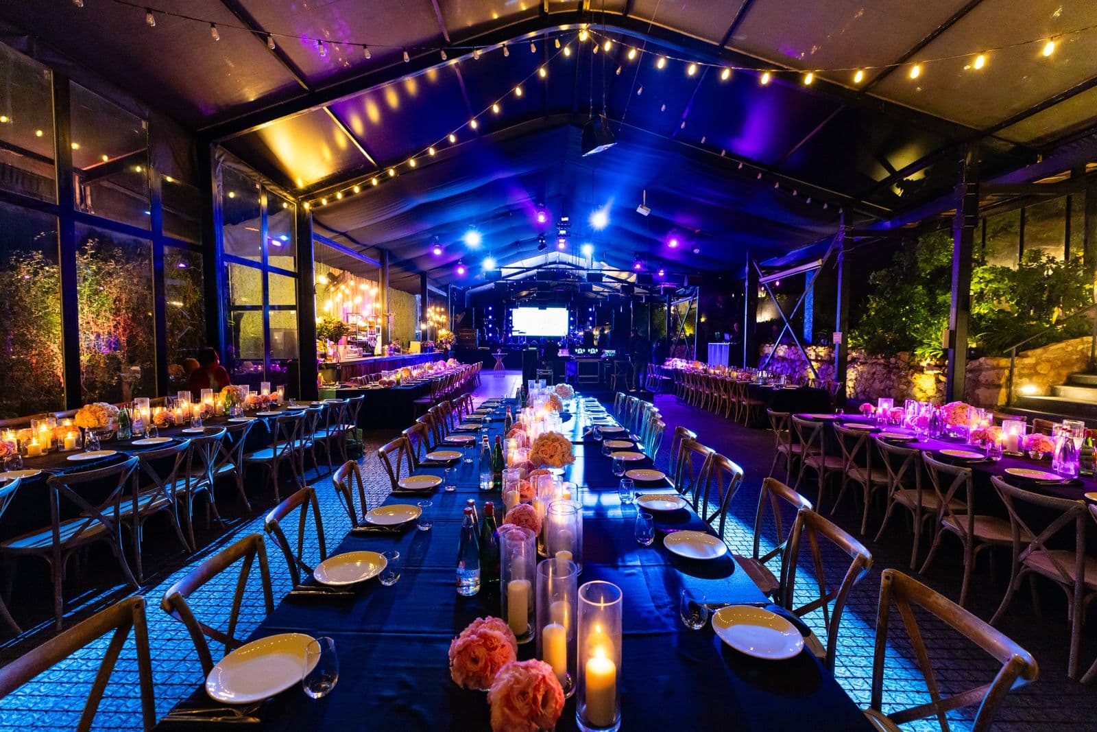 Elegant indoor event venue styled with ambient lighting and coordinated table settings