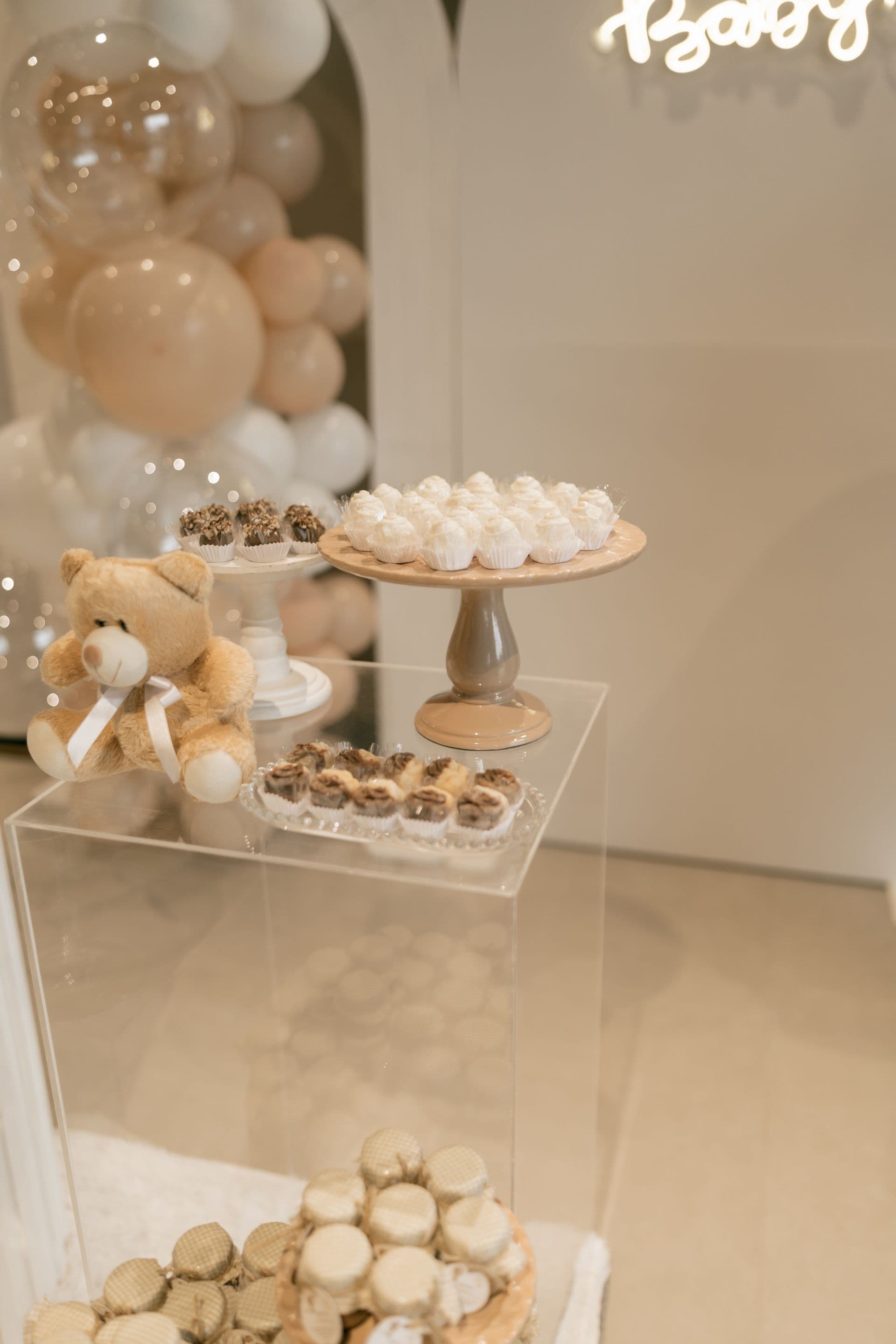 Elegant cream and gold balloon garland backdrop framing a styled dessert display