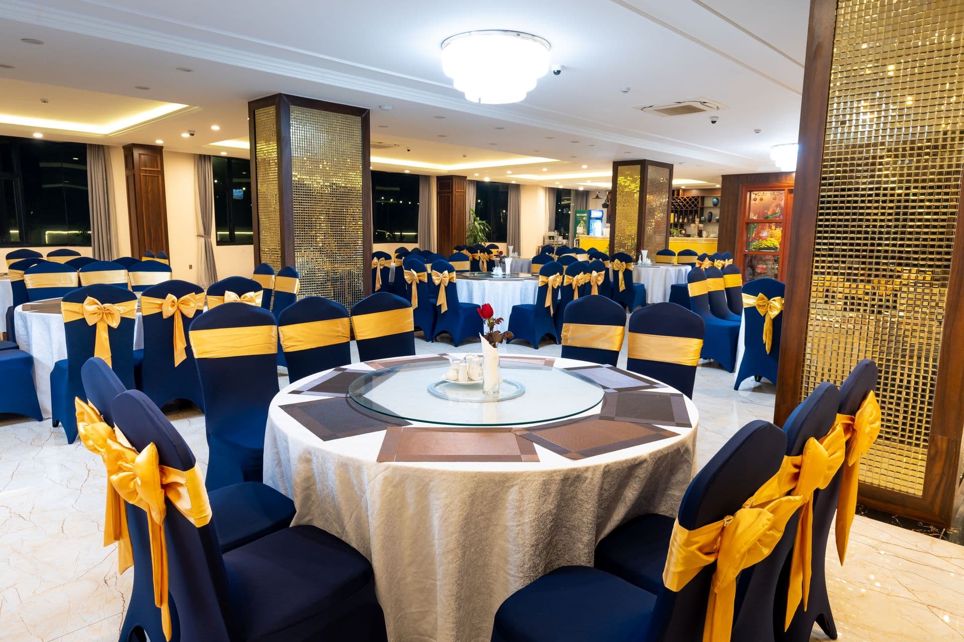 Luxurious banquet hall with navy and gold table settings prepared for a formal corporate event