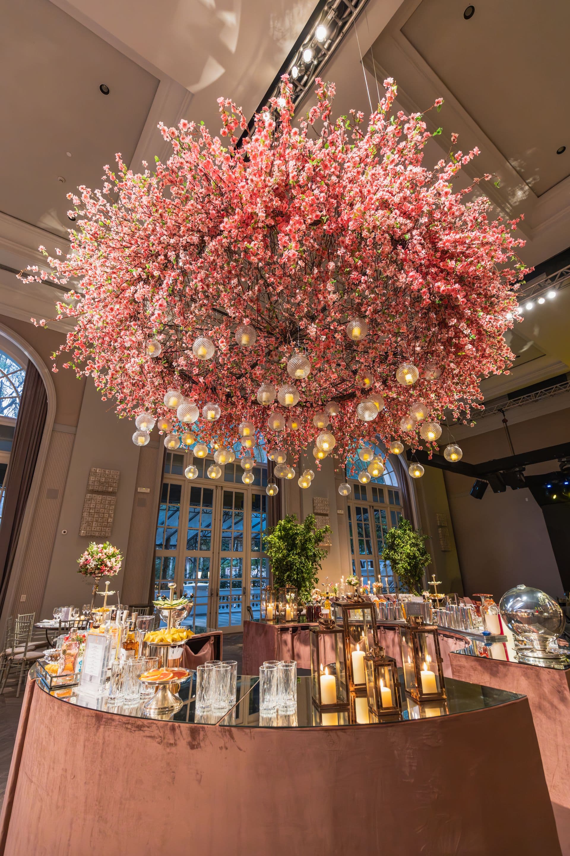 Dramatic suspended pink floral installation over a styled venue reception area